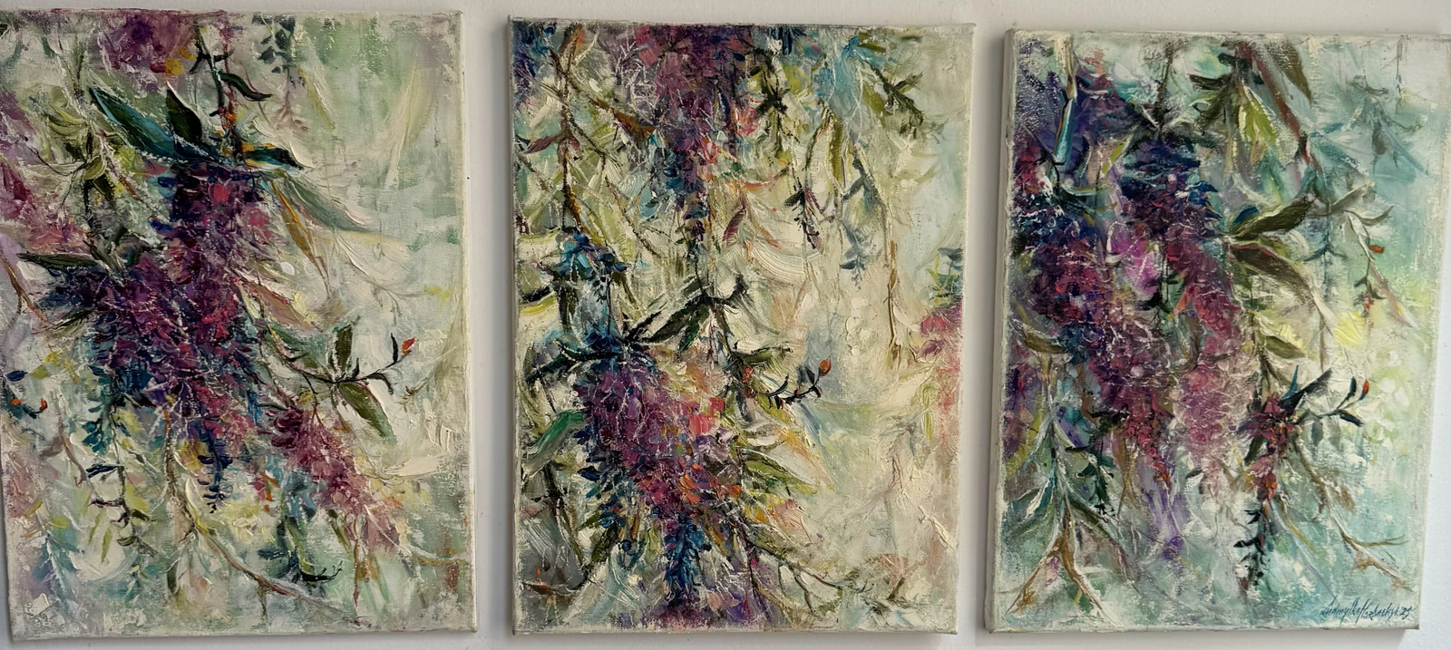Three coordinated panels explore cascading clusters of purple blossom and dark green leaves. Pale mint, cream and blue passages weave between loose branches, with raised strokes and small bright accents giving each panel its own rhythm.
