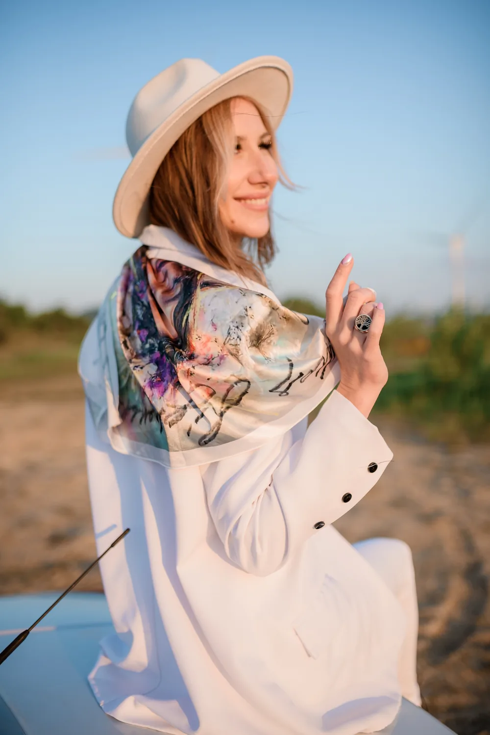 An archived portrait scarf worn over a white coat outdoors