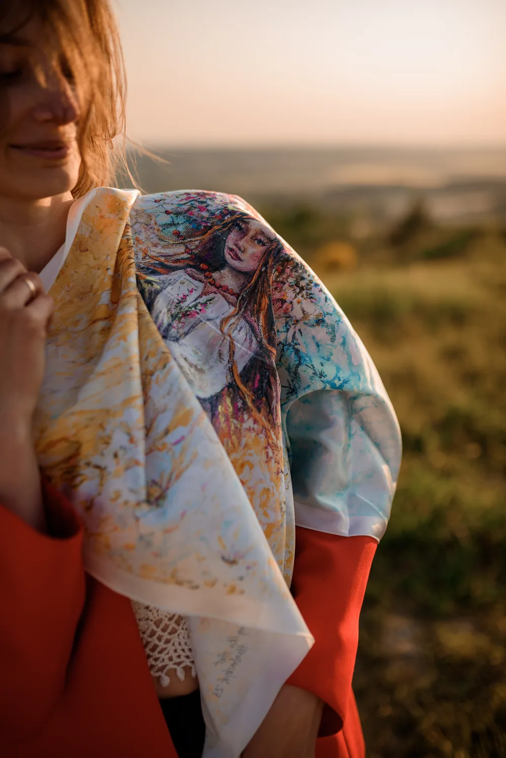 An archived scarf with a female portrait draped over a red coat