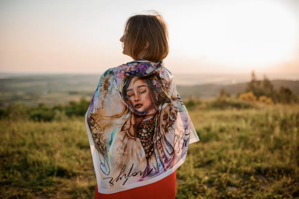 An archived portrait scarf worn across the shoulders at sunset