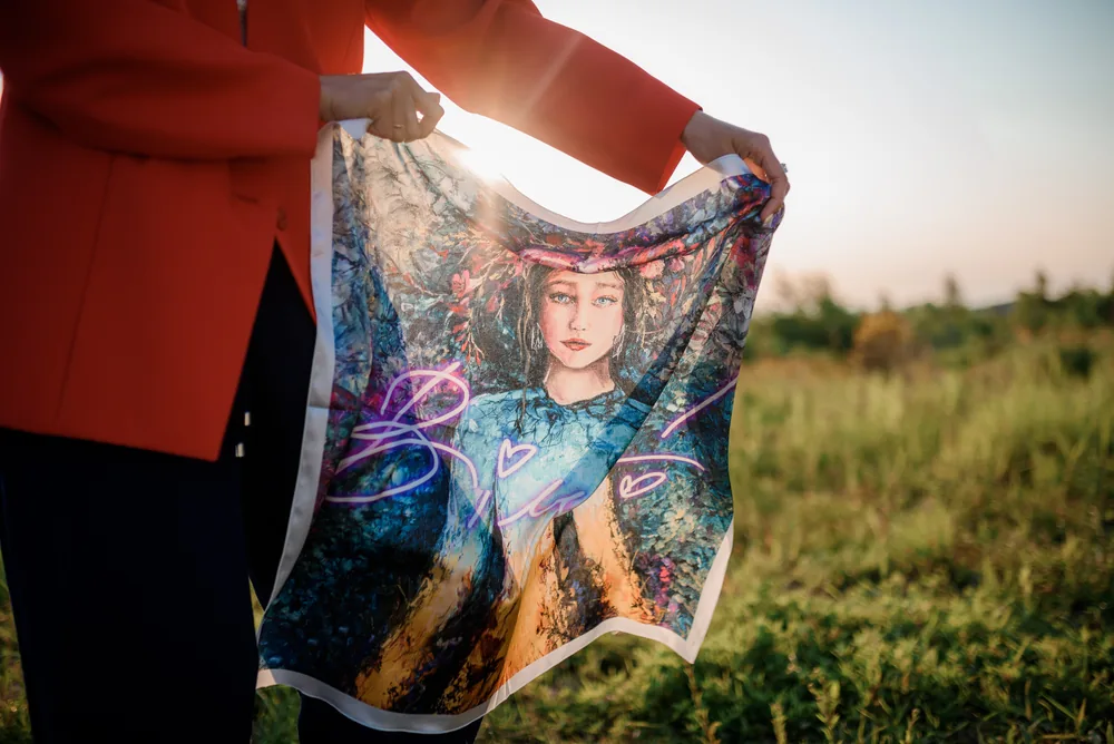 An archived blue and gold portrait scarf held open outdoors