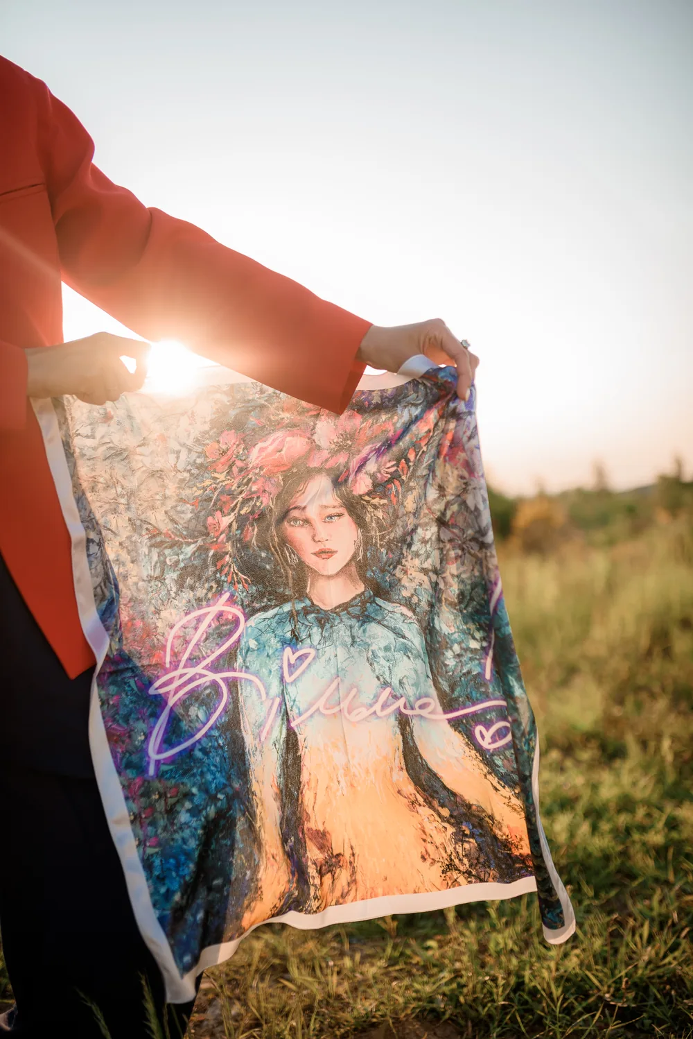 An archived blue and gold scarf with pink lettering in evening light